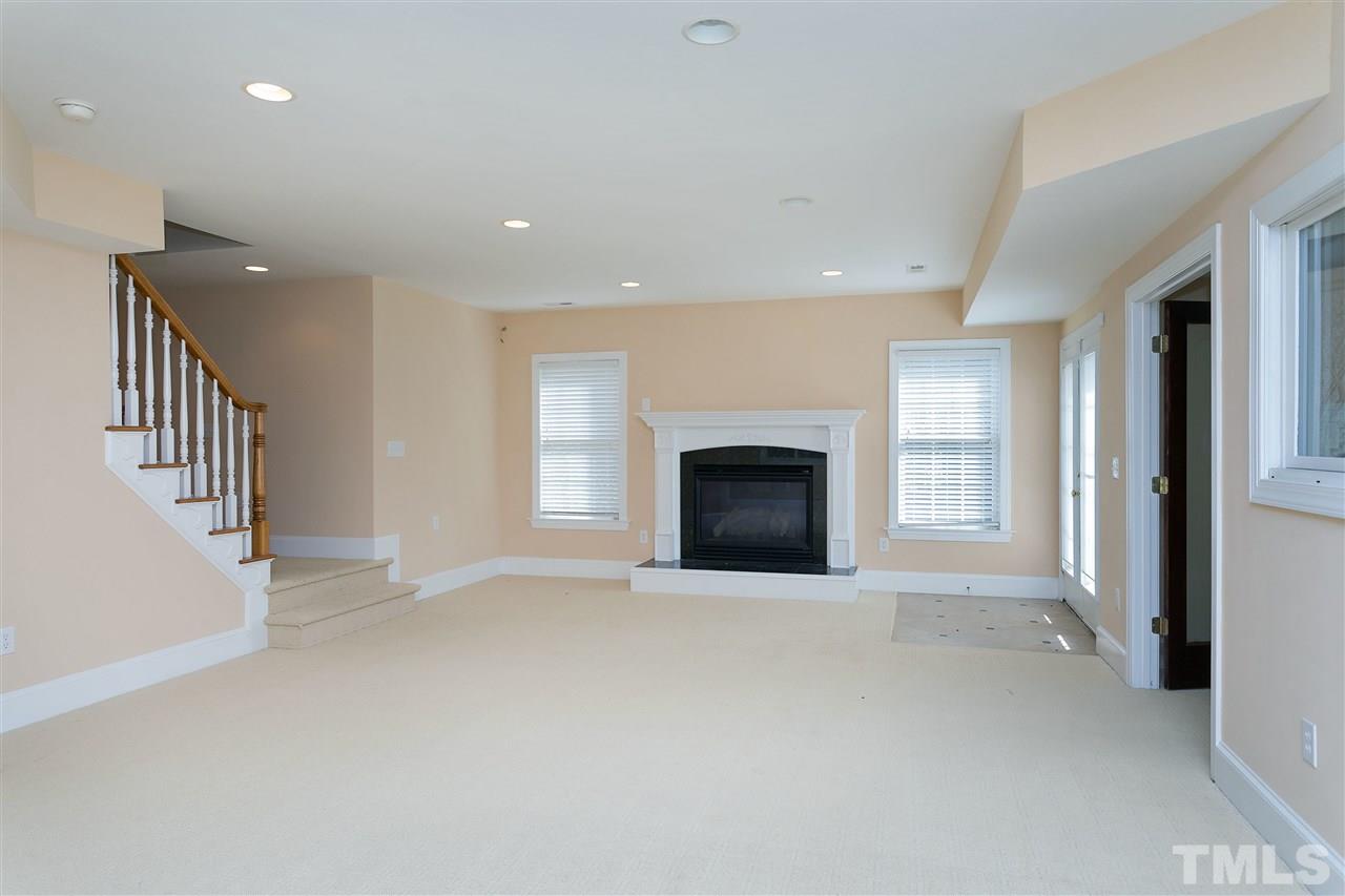 9505 Bluemont Court Raleigh, NC 27617 - Photo 19 of 25 an empty room with fireplace and windows