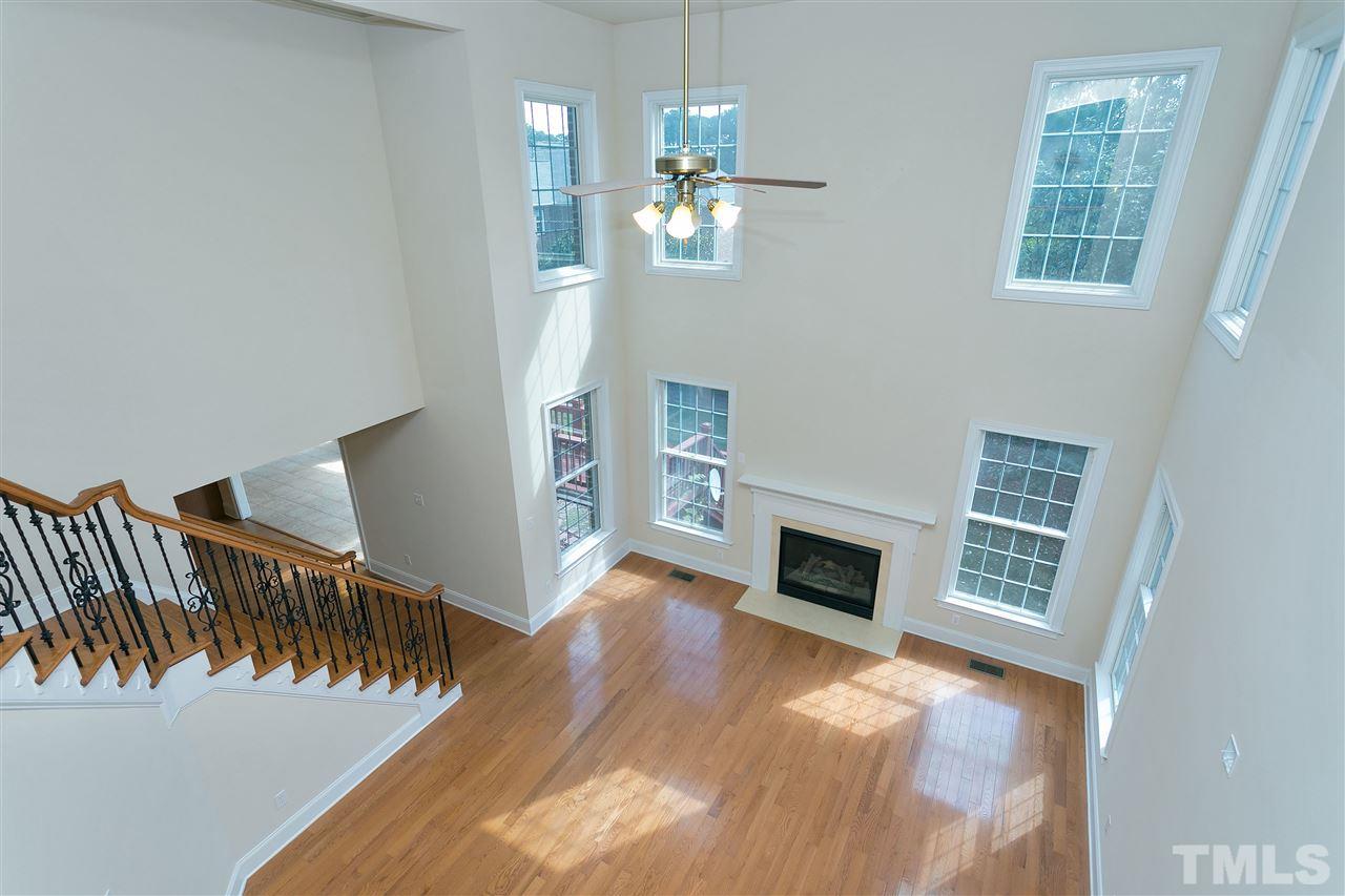 9505 Bluemont Court Raleigh, NC 27617 - Photo 7 of 25 a view of a livingroom with wooden floor fireplace and stairs