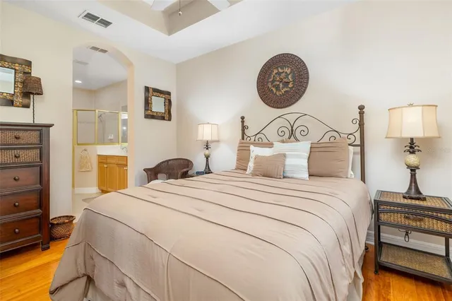 a bedroom with a bed a clock on wall and a large window
