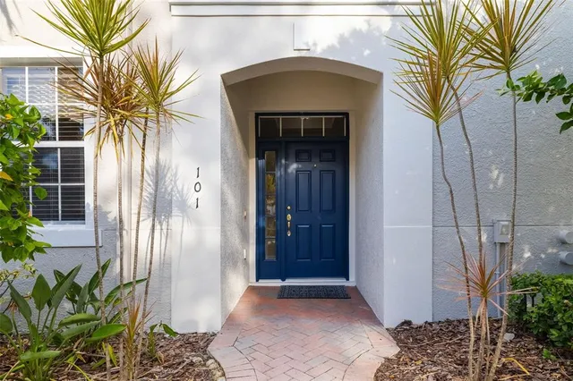 a view of a entryway door with potted plants in front of house