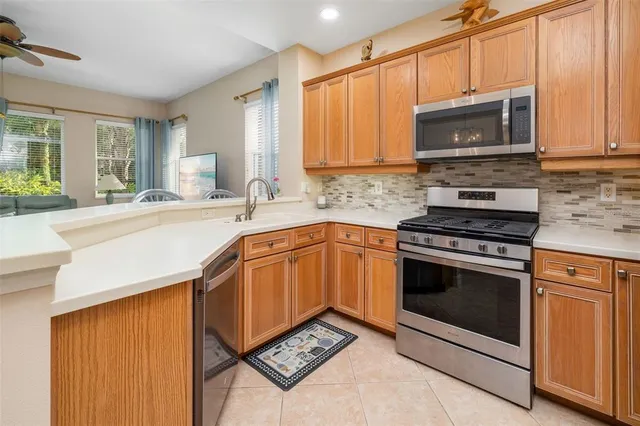 a kitchen with stainless steel appliances a stove a microwave sink and cabinets
