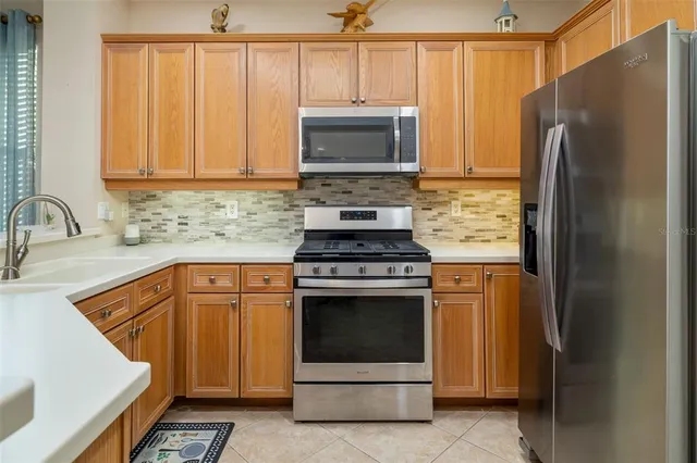 a kitchen with granite countertop a sink stove and refrigerator