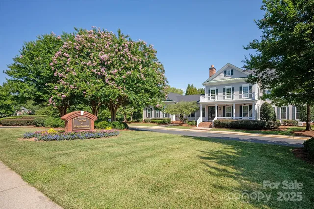 a front view of a building with a garden and trees