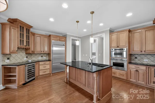 a kitchen with stainless steel appliances granite countertop a stove refrigerator and cabinets