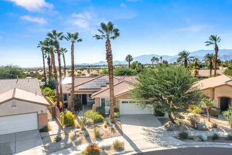 a view of a palm trees front of the house