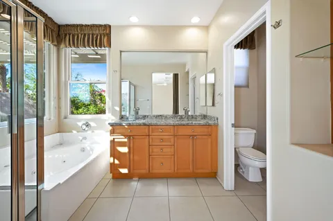 a bathroom with a granite countertop sink and a large mirror