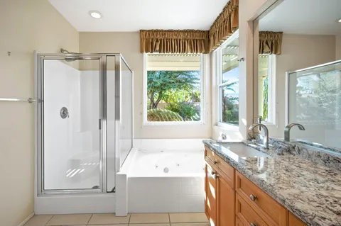 a bathroom with a granite countertop tub and a sink
