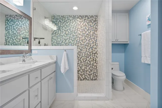 a bathroom with a sink a toilet and shower