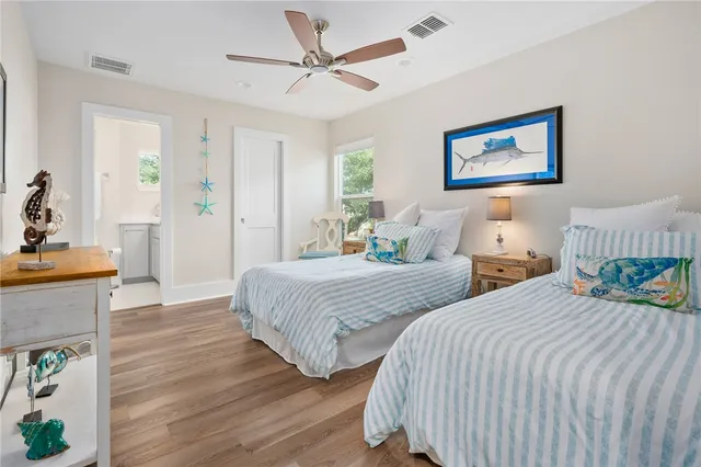 a bedroom with two beds and painting on the wall