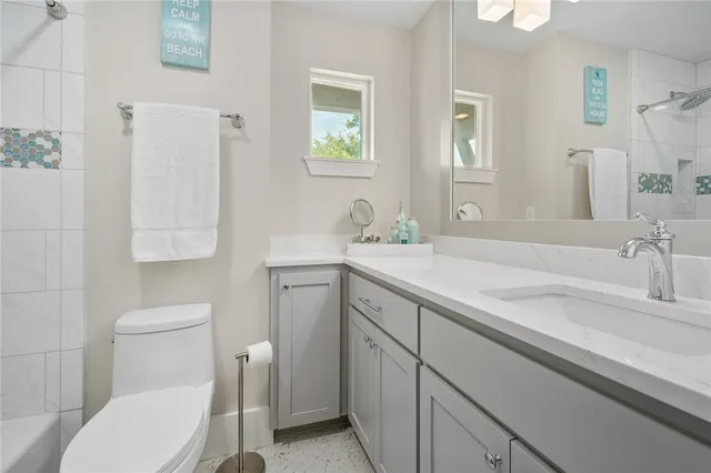 a bathroom with a granite countertop toilet sink and mirror