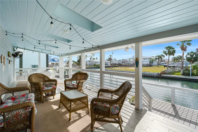 a view of a dining room with furniture one side kitchen view and wooden floor