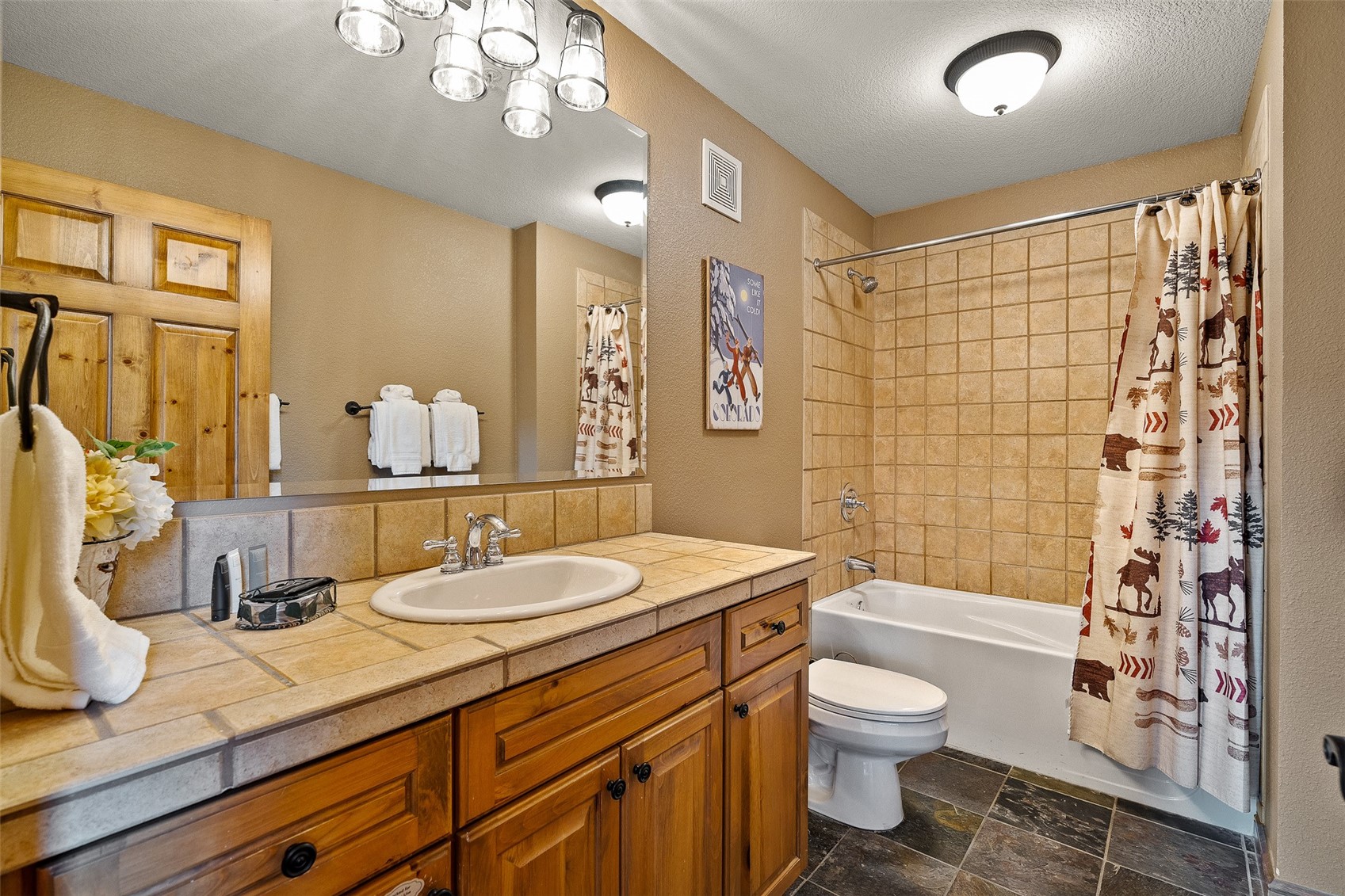 57 Lake Ridge Circle, Unit 1848 Keystone, CO 80435 - Photo 25 of 49 a bathroom with a granite countertop sink toilet a large mirror a shower and a bathtub