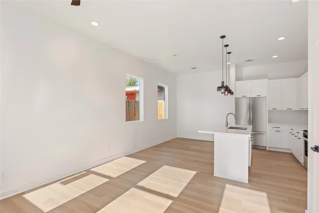 a kitchen with stainless steel appliances white cabinets and a refrigerator