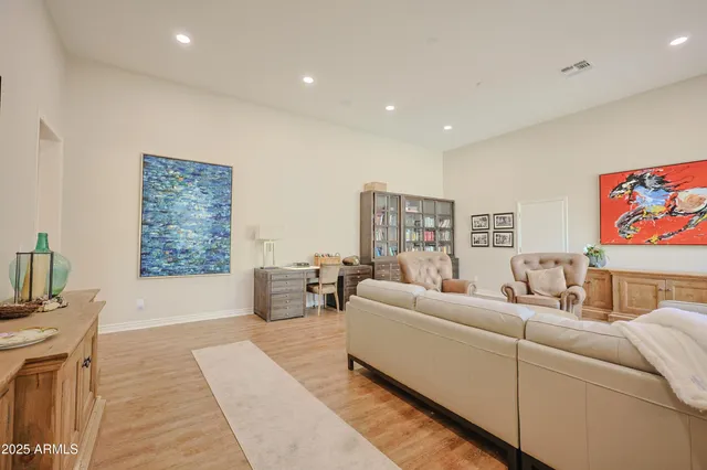 a spacious bedroom with a bed and wooden floor