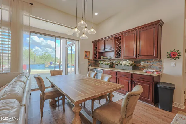 a dinning room with furniture a fireplace and wooden floor