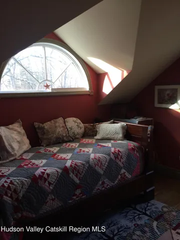 a bed sitting in a bedroom next to a window