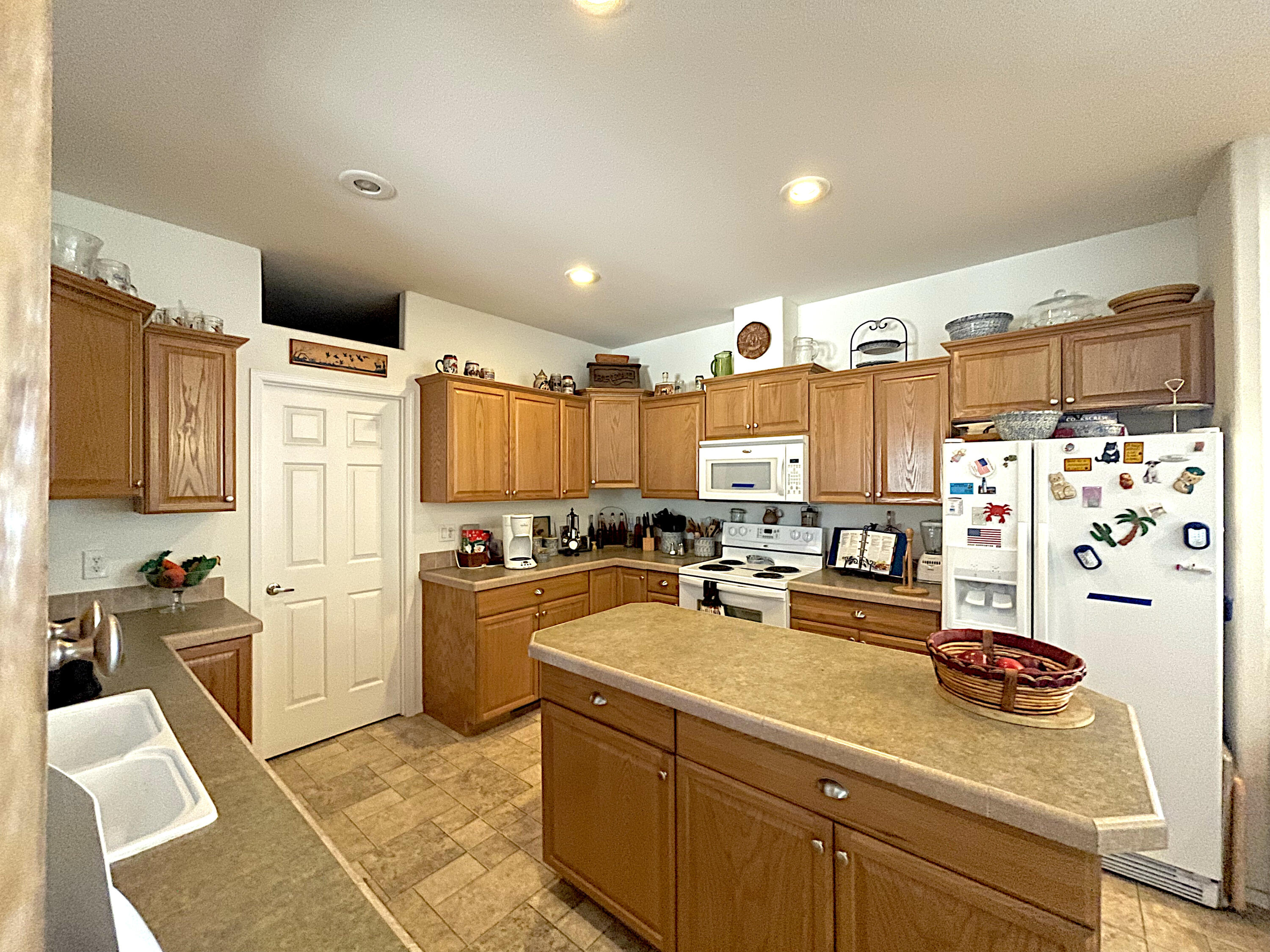 4911 Rockydale Road Cave Junction, OR 97523 - Photo 13 of 25 a kitchen with refrigerator a stove a sink and white cabinets with wooden floor
