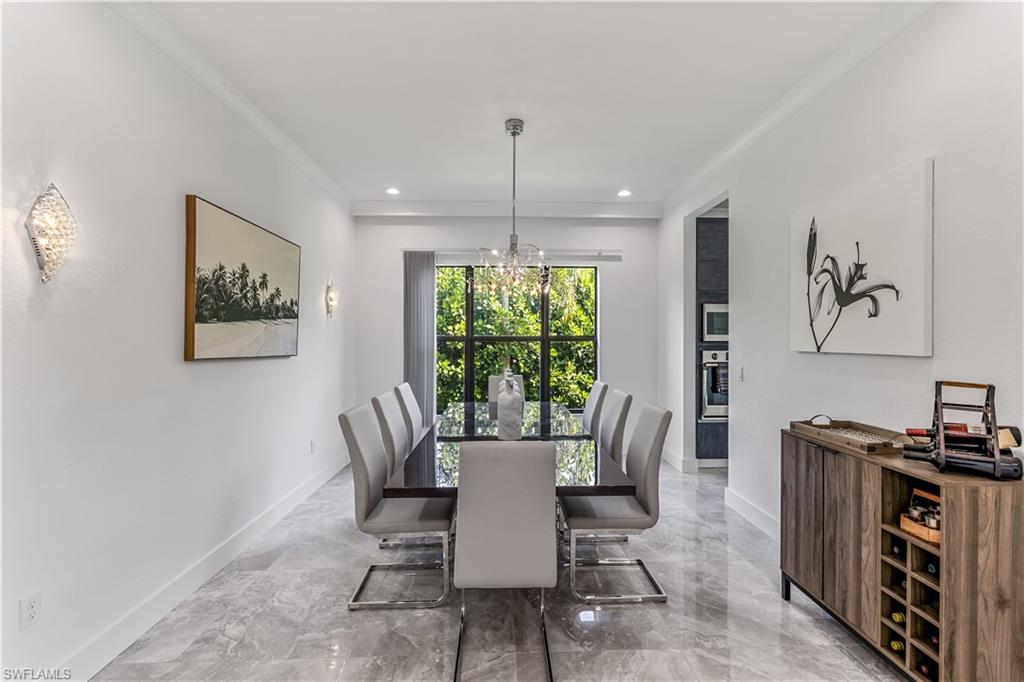 4410 Caldera Circle Naples, FL 34119 - Photo 11 of 30 a dining room with furniture a window and a chandelier