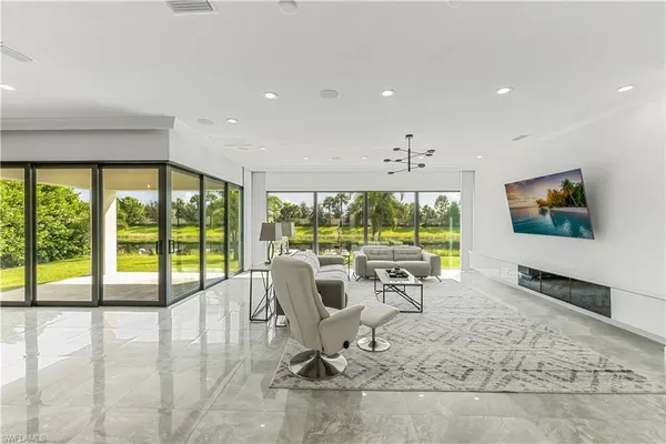 a living room with large windows and a flat screen tv
