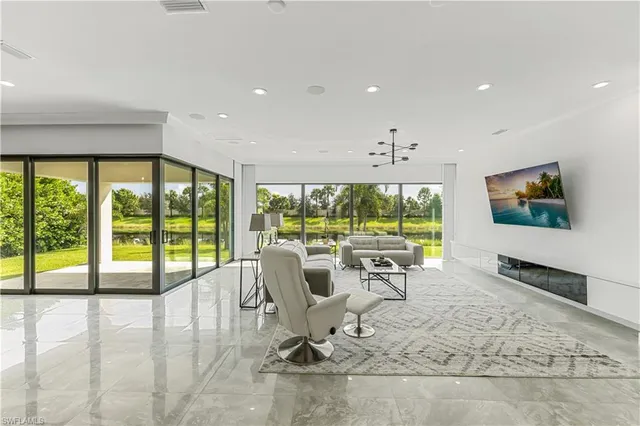 a living room with large windows and a flat screen tv