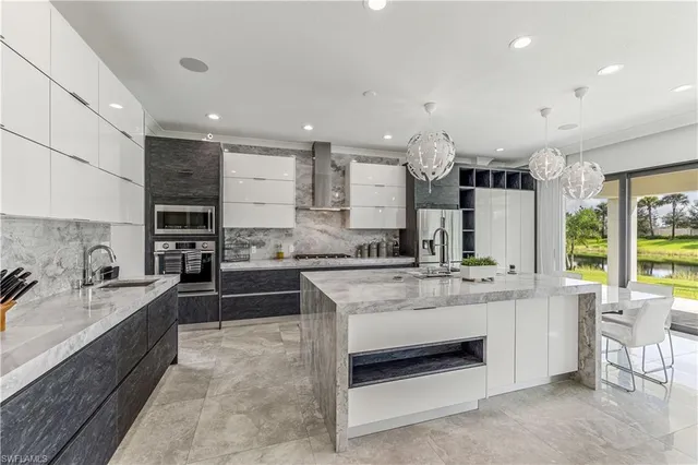 a large white kitchen with a large window and stainless steel appliances