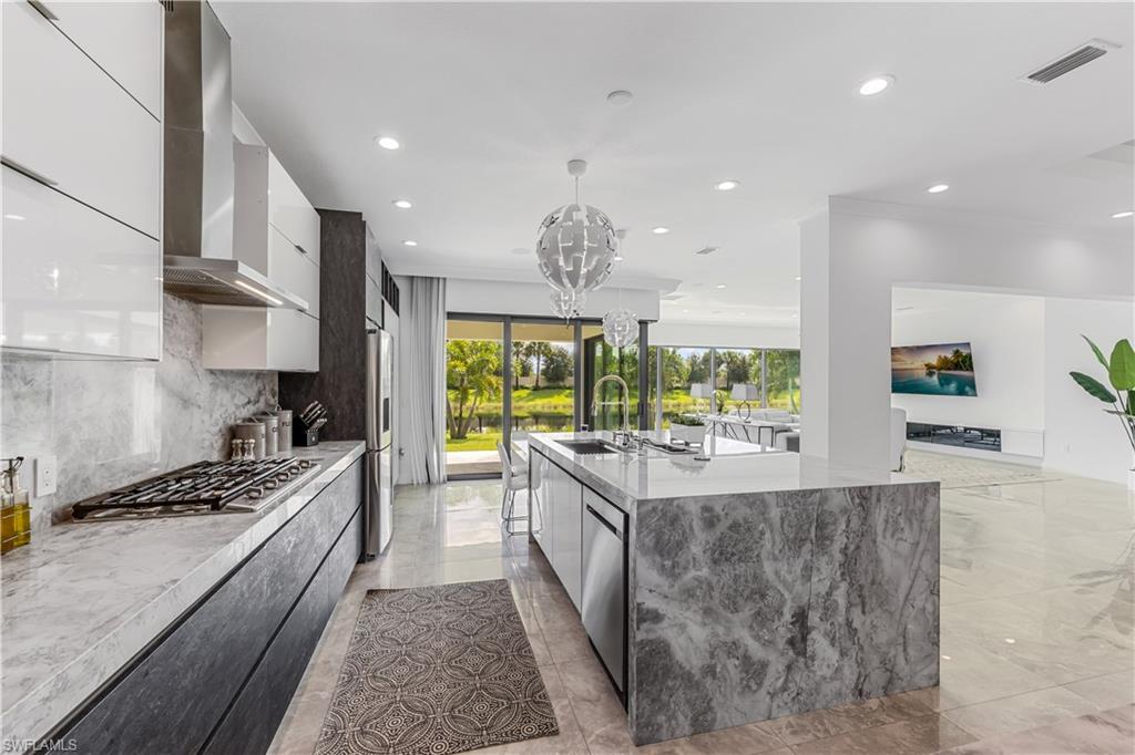 4410 Caldera Circle Naples, FL 34119 - Photo 16 of 30 a kitchen with stainless steel appliances granite countertop a stove and a large window