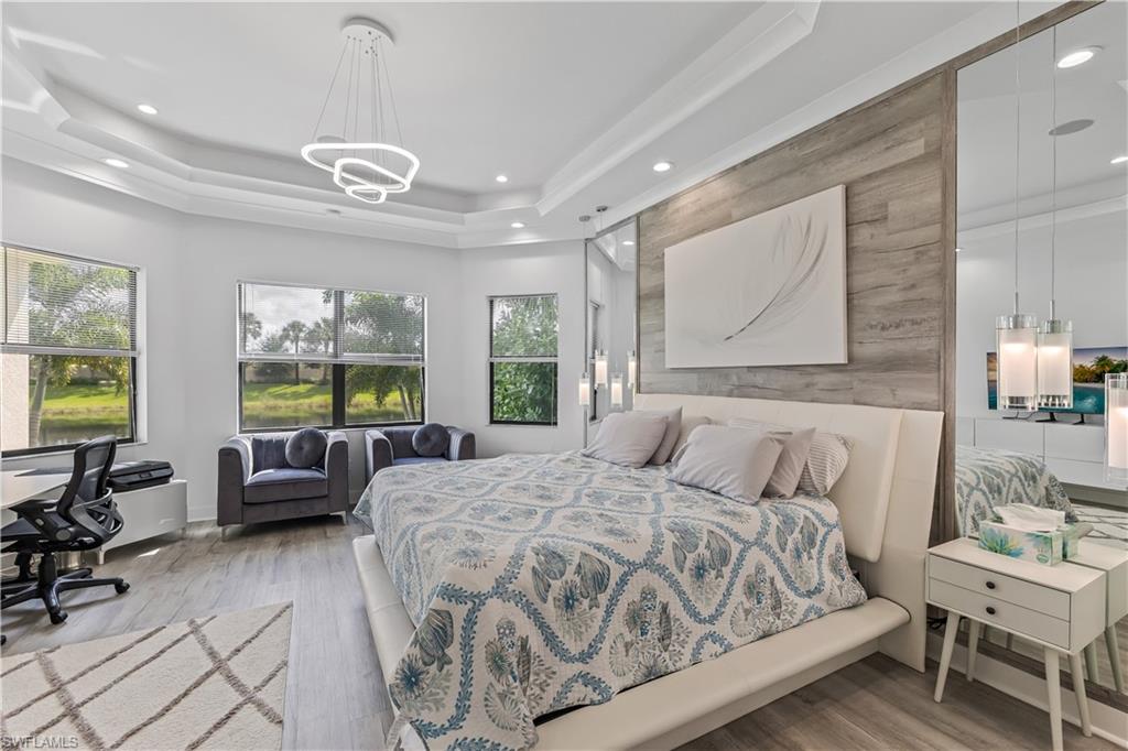 4410 Caldera Circle Naples, FL 34119 - Photo 21 of 30 a spacious bedroom with a bed a couch and dresser