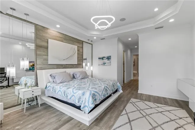 a bedroom with a large bed and a chandelier