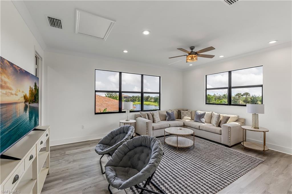 4410 Caldera Circle Naples, FL 34119 - Photo 26 of 30 a living room with furniture a flat screen tv and a large window