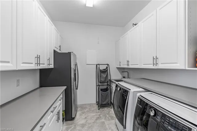a kitchen with a refrigerator sink and cabinets