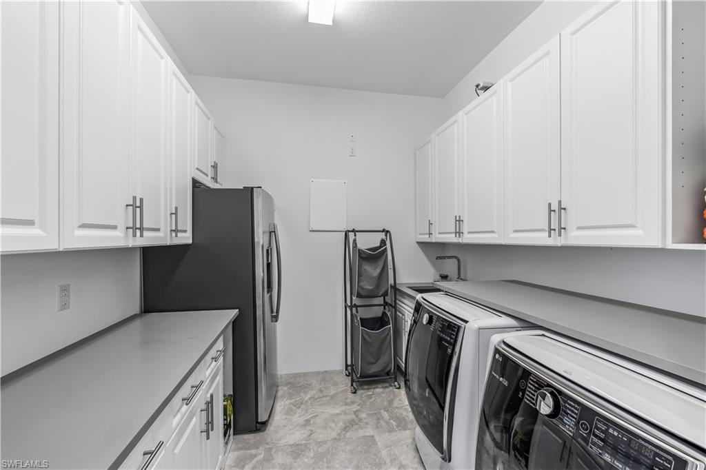 4410 Caldera Circle Naples, FL 34119 - Photo 5 of 30 a kitchen with a refrigerator sink and cabinets