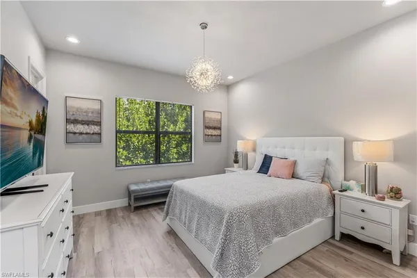 a spacious bedroom with a bed and a flat screen tv