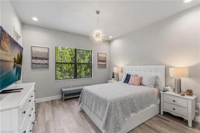 a spacious bedroom with a bed and a flat screen tv