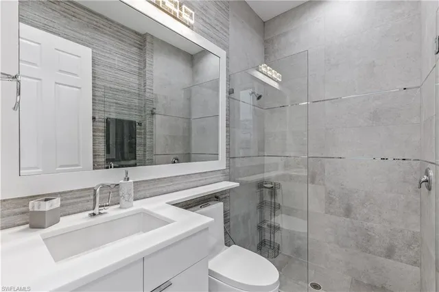 a bathroom with a sink toilet vanity and shower