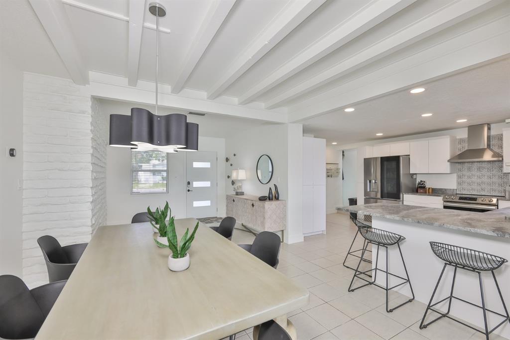 387 12th Avenue Indian Rocks Beach, FL 33785 - Photo 19 of 44 a kitchen with stainless steel appliances kitchen island granite countertop a table and chairs in it
