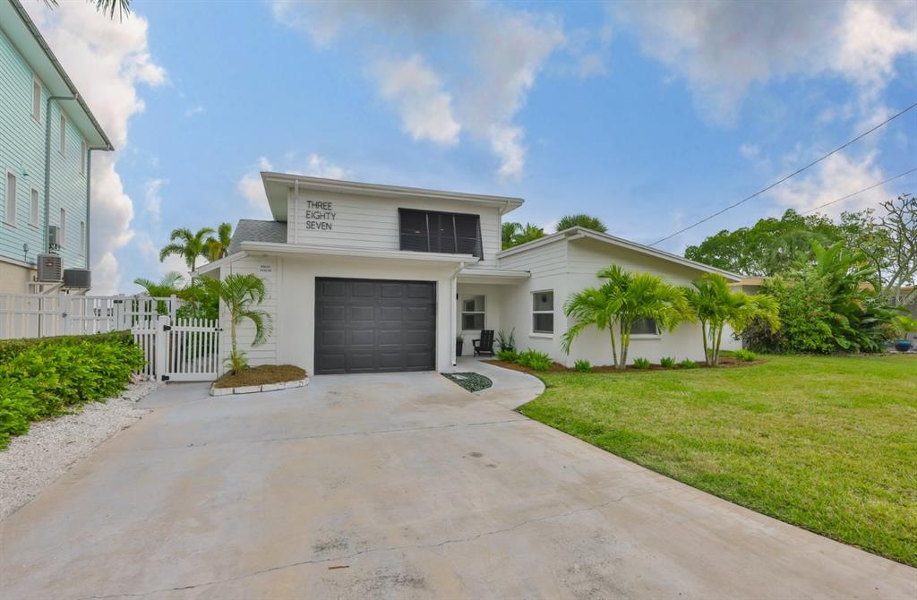 387 12th Avenue Indian Rocks Beach, FL 33785 - Photo 2 of 44 a front view of a house with a yard and garage