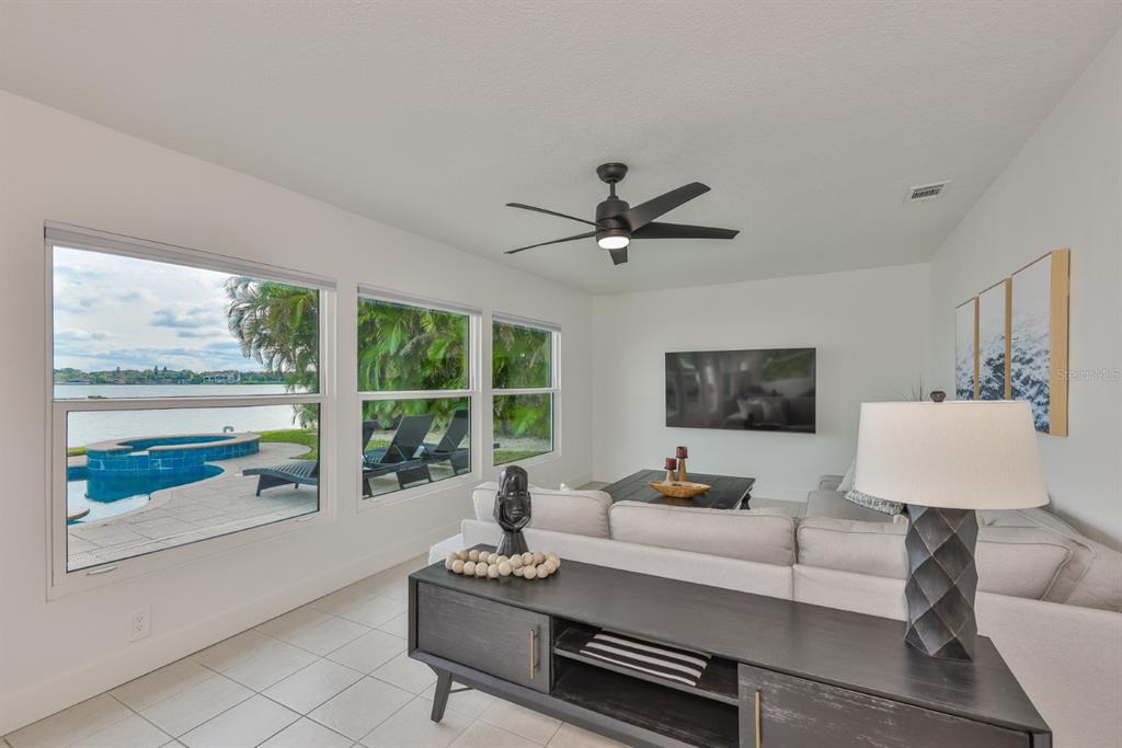 387 12th Avenue Indian Rocks Beach, FL 33785 - Photo 24 of 44 a living room with furniture floor to ceiling window and a flat screen tv