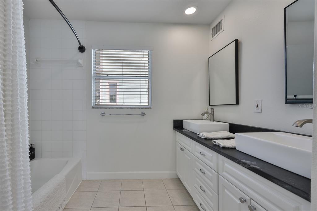 387 12th Avenue Indian Rocks Beach, FL 33785 - Photo 37 of 44 a bathroom with a granite countertop sink and a bathtub