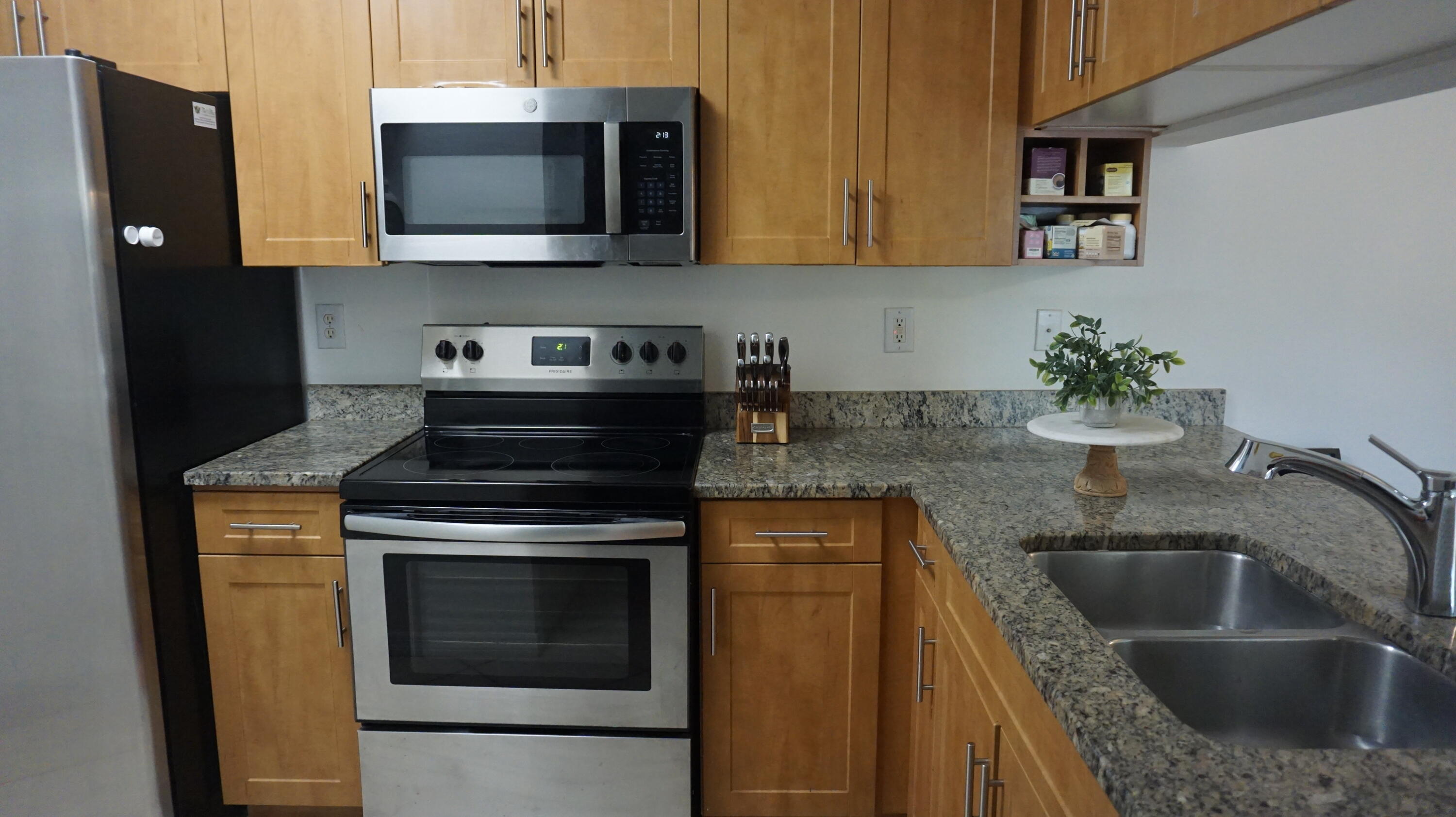 6511 Emerald Dunes Drive, Unit 208 West Palm Beach, FL 33411 - Photo 14 of 51 a kitchen with stainless steel appliances granite countertop a sink stove and microwave