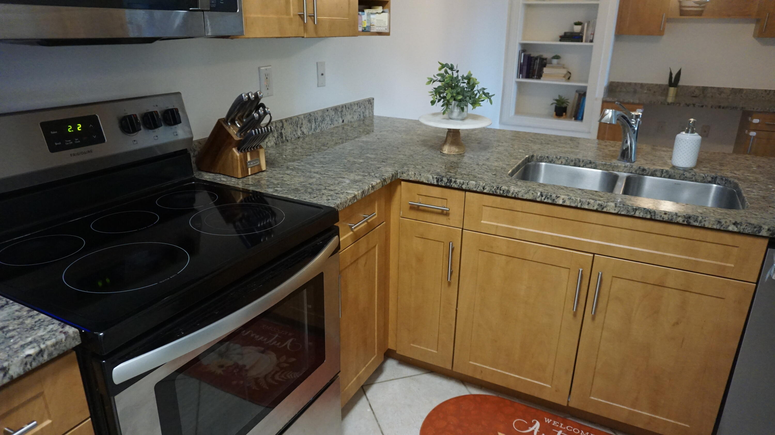 6511 Emerald Dunes Drive, Unit 208 West Palm Beach, FL 33411 - Photo 15 of 51 a kitchen with granite countertop stainless steel appliances stove microwave and cabinets