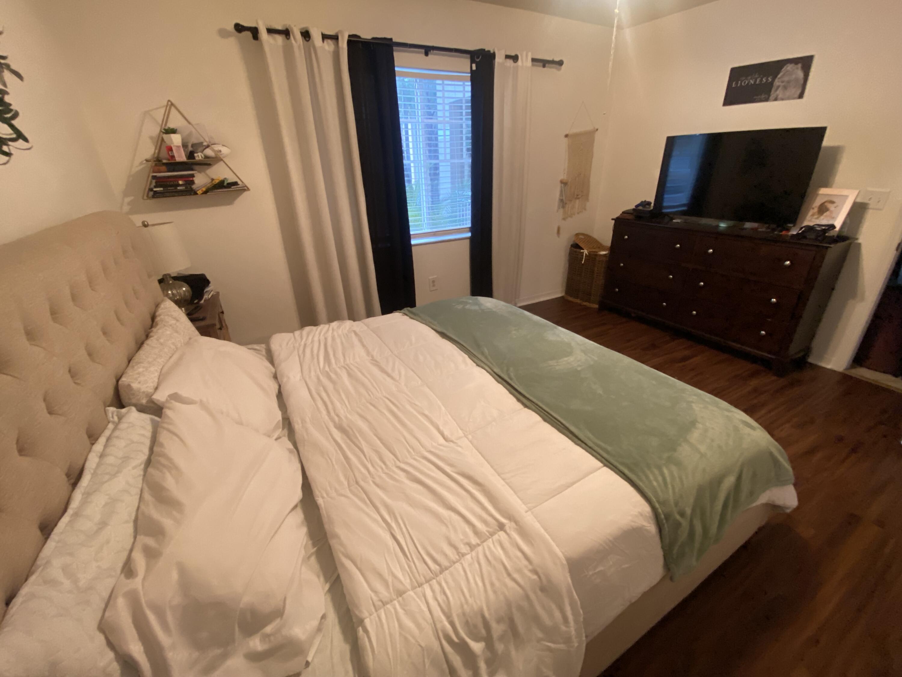 6511 Emerald Dunes Drive, Unit 208 West Palm Beach, FL 33411 - Photo 23 of 51 a bedroom with a bed and a flat screen tv