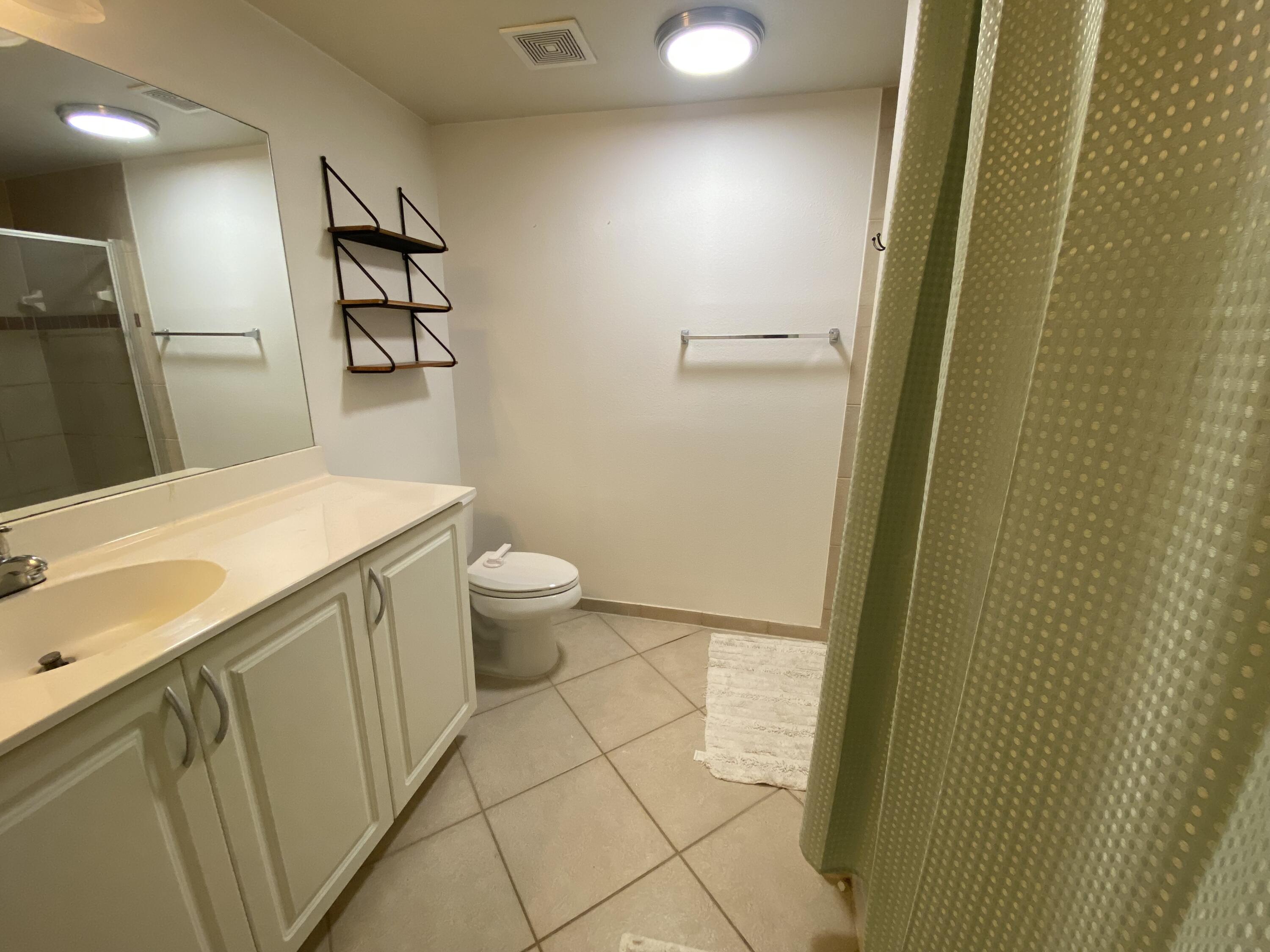 6511 Emerald Dunes Drive, Unit 208 West Palm Beach, FL 33411 - Photo 28 of 51 a bathroom with a sink and a mirror