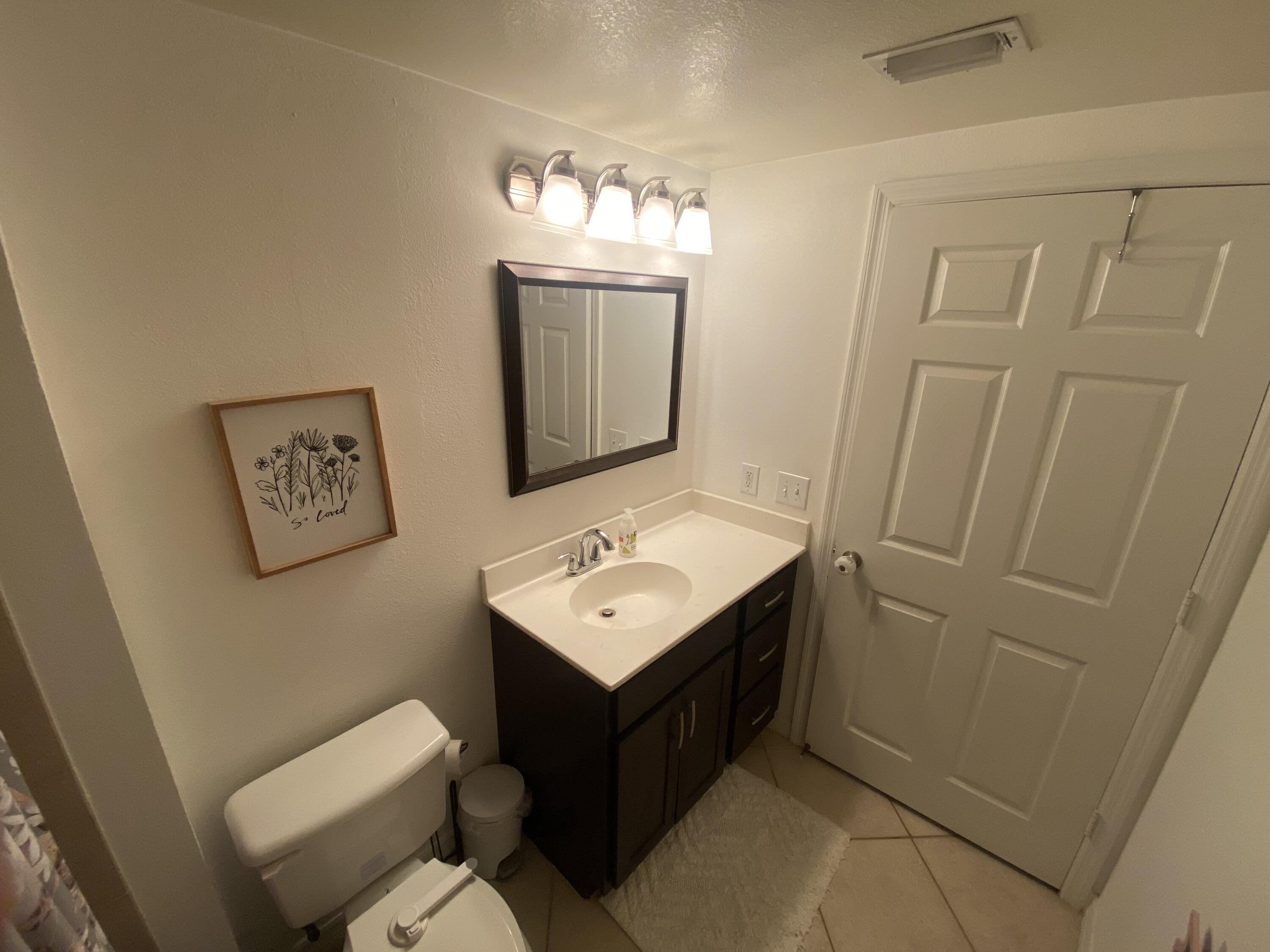 6511 Emerald Dunes Drive, Unit 208 West Palm Beach, FL 33411 - Photo 40 of 51 a bathroom with a sink mirror and toilet
