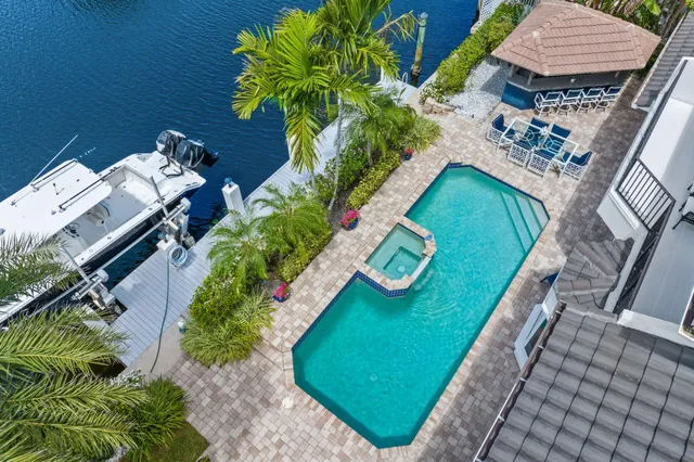 a view of a chairs and table in patio with a swimming pool