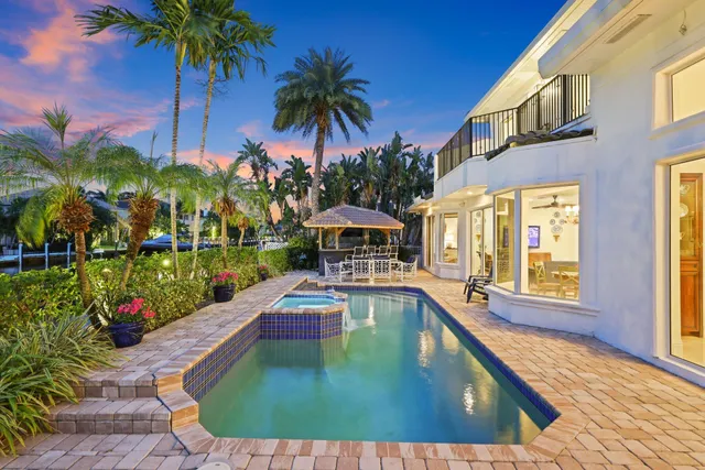a view of a patio with dining table and chairs with plants and wooden floor