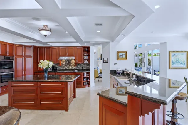 a kitchen with stainless steel appliances kitchen island granite countertop a stove refrigerator and cabinets