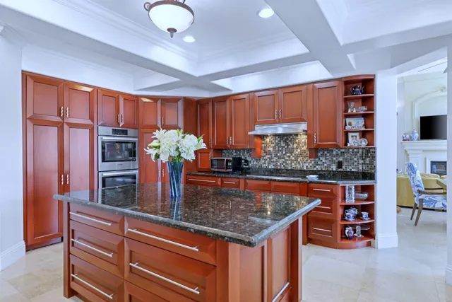 a kitchen with stainless steel appliances granite countertop a stove refrigerator and cabinets