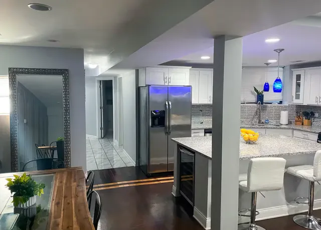 a kitchen with stainless steel appliances granite countertop a refrigerator a stove and a sink