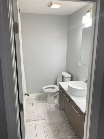 a bathroom with a toilet a sink and a mirror