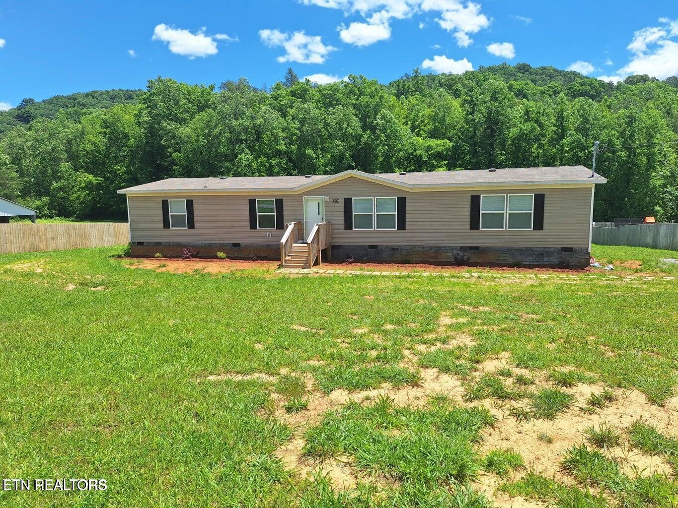 1450 Belltown Road Tellico Plains, TN 37385 - Photo 1 of 32 a house that is sitting in the grass with large trees and plants